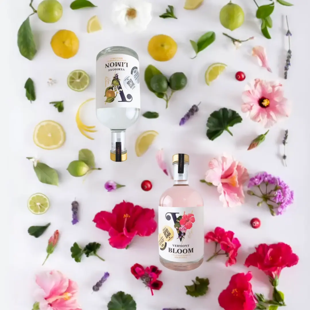 title="VerGin Bloom & Limón – Refreshing Alcohol-Free Botanical Spirits with Citrus and Floral Notes" alt="VerGin Bloom and Limón bottles displayed on bed of fresh lemons, limes, and flowers – alcohol-free botanical spirits"